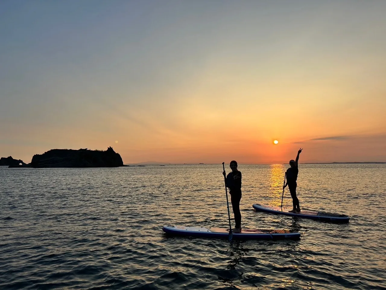 夕暮れの海でSUPを楽しむ参加者