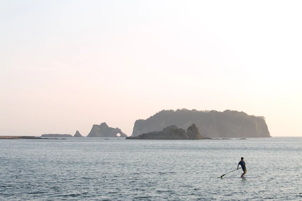 島々を背景に海上でSUPを楽しむ代表の大野靖幸